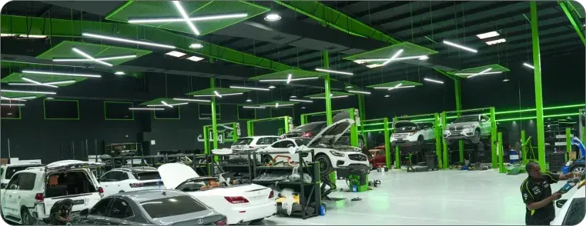 Inside the Exotic Auto Services workshop with green lifts and service bays